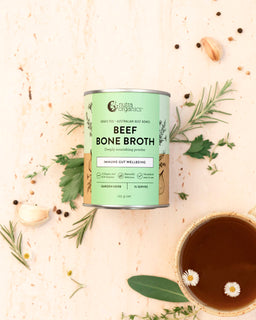 a flat lay image of a tin of beef bone broth garden herb and mug of broth