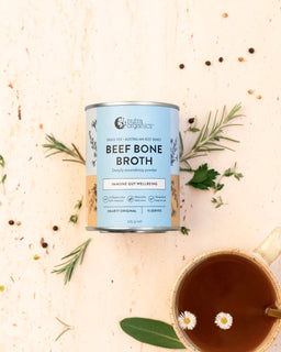 a flat lay image of a tin of beef bone broth hearty original and mug of broth