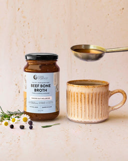 A mug of broth sits next to a jar of Nutra Organic's Beef Bone concentrate natural beef