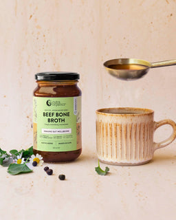 A mug of broth sits next to a jar of Nutra Organic's Beef Bone Broth concentrate native herb