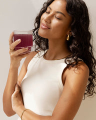 Lady holding a glass of collagen beauty blueberry wildflower