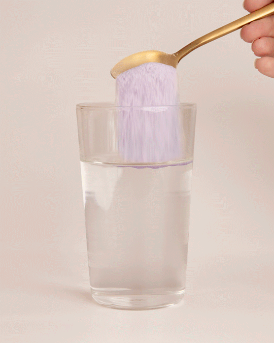 Collagen beauty blueberry wildflower being stirred into a glass of water