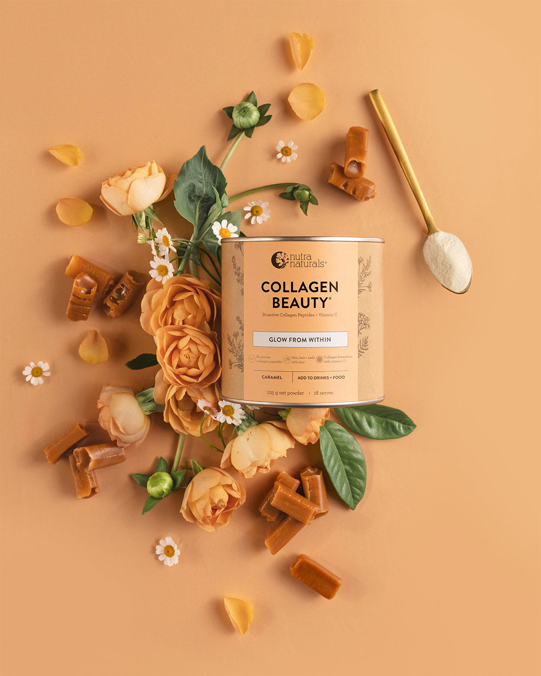 A can of Collagen Beauty powder is styled in a flat lay with peach roses, green leaves, small white daisies, scattered collagen peptides, and a gold spoon on a peach background.