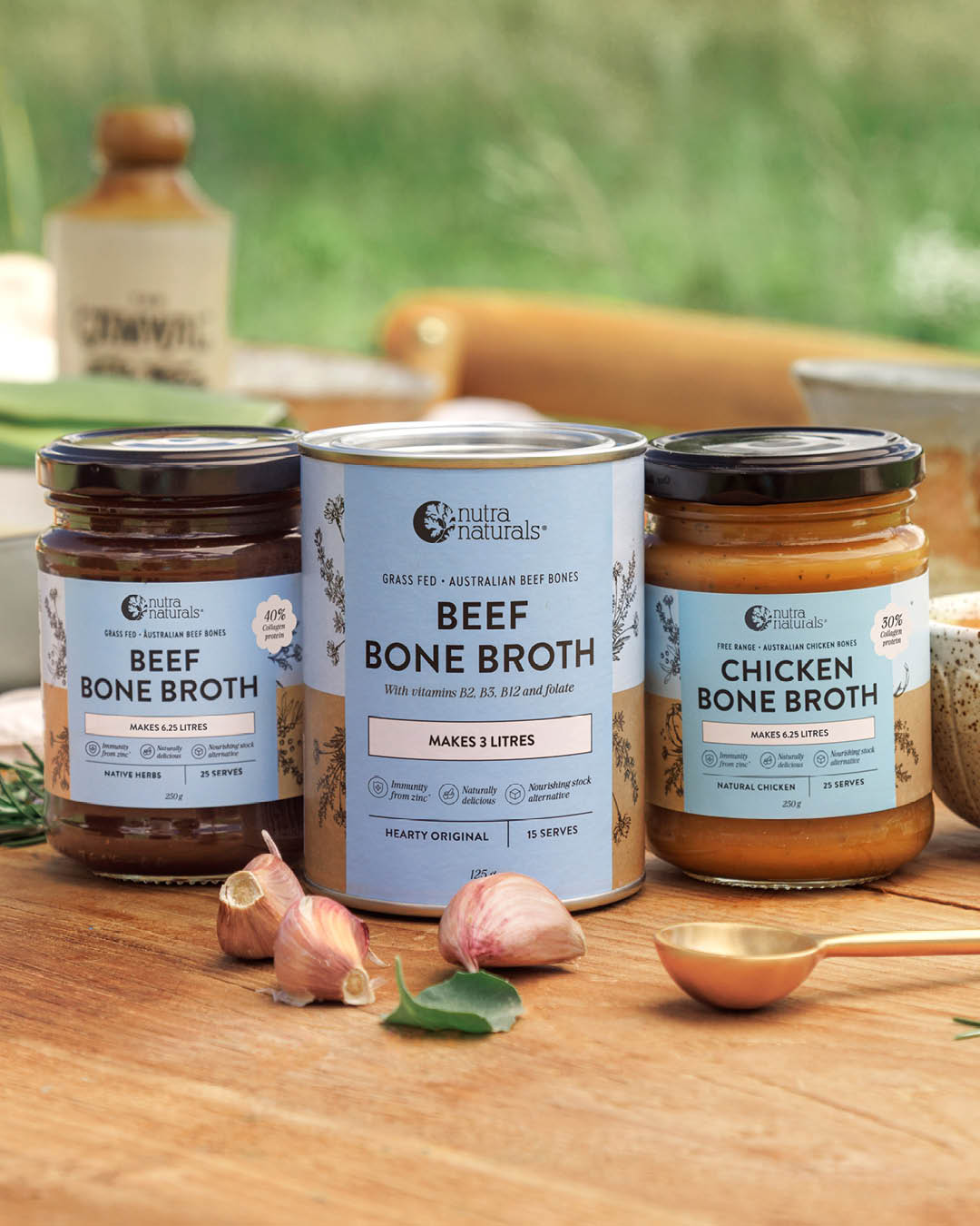 Three jars of Nutra Naturals bone broth products arranged on a wooden table