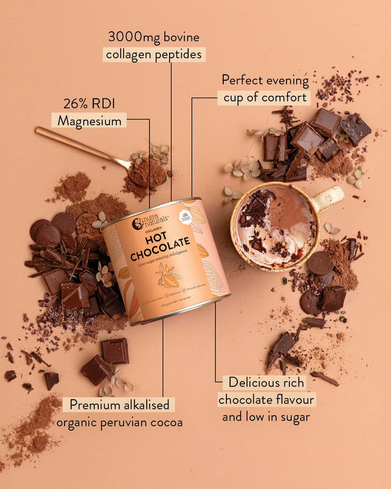 A can of Hot Chocolate Collagen centered on a peach background, surrounded by chocolate pieces, cocoa powder, and a cup of chocolate drink. Text callouts highlight ingredients and flavor claims.