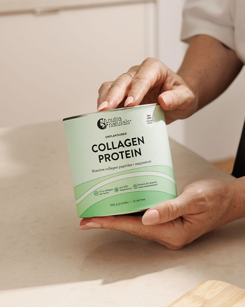 A person holds a canister of Collagen Protein powder