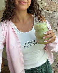 Woman holding a green smoothie with a straw