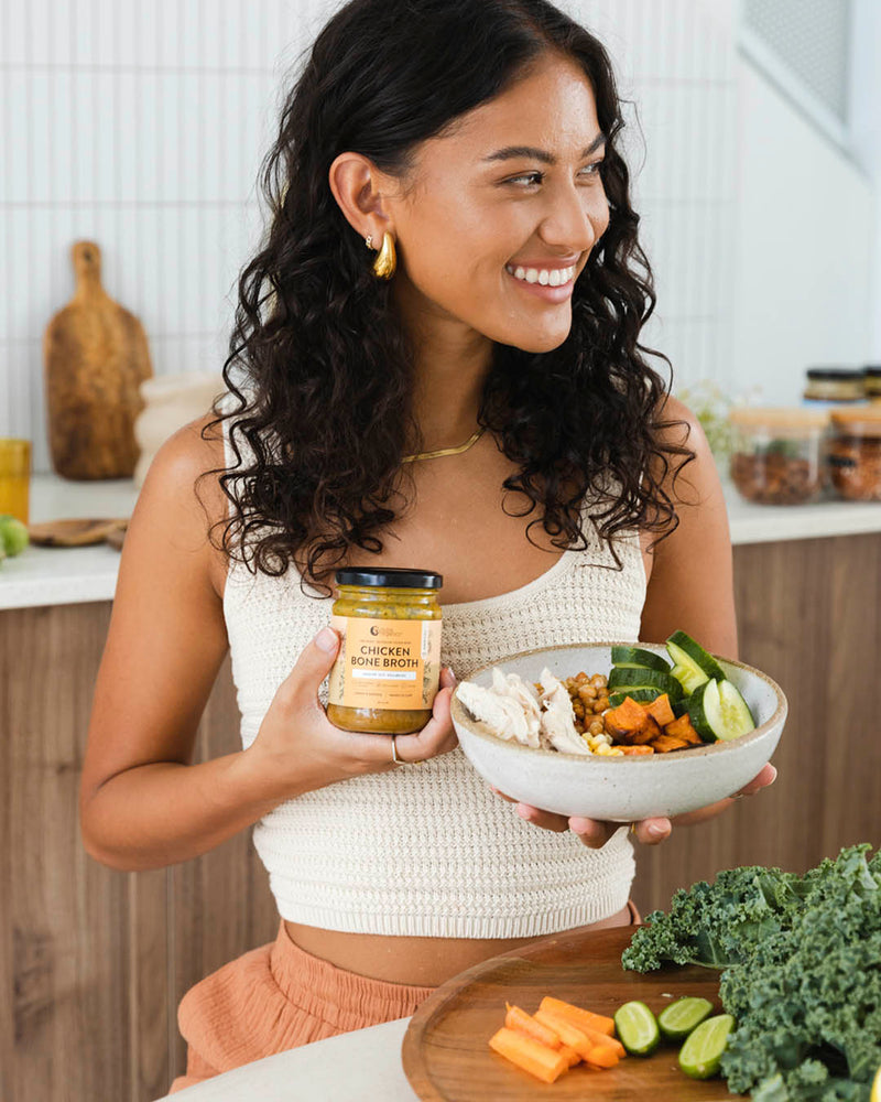 Model holding chicken bone broth lemon paprika