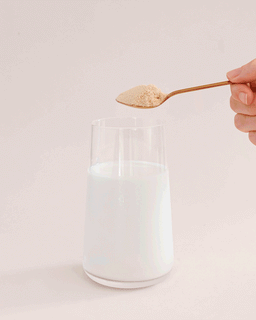 Stirring the vanilla protein powder in a glass of milk